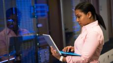IT checks info on laptop in front of IT room