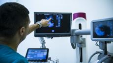 doctor points at an image on one screen at a multi-screen medical station