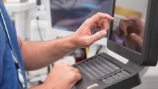 Healthcare worker using touchscreen computer terminal