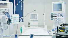 Empty hospital bed with many monitors around