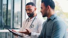 Doctor showing tablet to patient