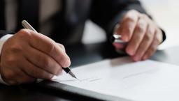 Businessperson signing piece of paper