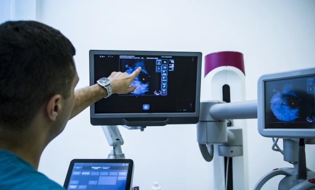 Healthcare worker pointing at x-ray image on monitor