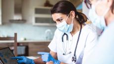 clinical researchers looking at data on a screen
