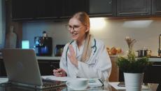 A doctor taking a virtual consultation from their kitchen and dining room